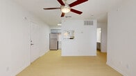 Located in Mesquite, TX, this efficiently designed single-floor unit offers a practical and well-organized layout across three bedrooms, a living room, and a kitchen. Light hardwood-style flooring runs throughout, giving the space a clean and cohesive look. Ceiling fans are present in multiple rooms, ensuring year-round comfort.

The open living area is bright and airy, with white walls and a pass-through window connecting to the kitchen, which is equipped with a stainless steel refrigerator, a range with overhead ventilation, and gray cabinetry. Natural light filters in through windows fitted with horizontal blinds and vertical blind-covered sliding doors, adding to the unit's welcoming atmosphere.

The primary bedroom is a comfortably sized retreat featuring a ceiling fan, a private en-suite bathroom, and direct access to a dedicated walk-in closet. Additional bedrooms are similarly well-lit, each with ceiling fans and generous wall space. Textured ceilings are a consistent design element throughout. The space is well-suited for those seeking a functional, move-in-ready home in the Mesquite area, with convenient access to Lyndon B. Johnson Freeway.