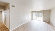 This 2-bedroom, 2-bathroom residence at 700 Moraine Ct in Virginia Beach, Virginia offers a thoughtfully laid-out single-floor plan with a clean, neutral aesthetic throughout. The living room is a bright, open space featuring light-toned luxury vinyl plank flooring, a textured ceiling, and large sliding glass doors fitted with vertical blinds that invite natural light and provide access to outdoor views of surrounding greenery. The updated kitchen is efficiently designed with light wood lower cabinetry, soft gray upper cabinets accented by gold hardware, white quartz countertops, a single-basin sink, and stainless steel appliances including a refrigerator and dishwasher. Both bedrooms are carpeted and bathed in natural light from windows with blinds. The spacious primary bedroom includes a generous closet, while the second bedroom also features a closet and direct access to a hallway. The two bathrooms offer clean, white fixtures — one with a soaking tub and surround, the other with a dedicated stand-up shower. Multiple closets and hallways throughout the unit provide ample storage. The overall ambiance is bright, fresh, and move-in ready, with a neutral palette that lends itself to easy personalization.
