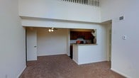 Located at 11132 Sunburst Ln in Fredericksburg, Virginia, this two-story residence offers a thoughtfully designed open-concept layout that maximizes both space and functionality. The main living area immediately impresses with its soaring double-height ceilings, which create a dramatic sense of openness and volume. A ceiling fan is centrally positioned to enhance airflow and comfort throughout the space.

The kitchen is seamlessly integrated into the main floor via a pass-through opening framed by a granite-topped breakfast bar, making it ideal for casual dining or entertaining. Rich, dark wood cabinetry provides ample storage, and the kitchen's layout allows for easy interaction with the adjacent living area.

Above the main floor, a second-level loft with a classic white balustrade railing overlooks the living space below, adding architectural character and providing additional flexible living or workspace. The carpeted main floor offers a warm, comfortable feel underfoot, complementing the neutral, light-toned walls that help reflect natural light throughout the interior.

The overall ambiance of this home is airy and inviting, with the interplay of vertical space, open sightlines, and functional design making it a versatile and comfortable residence in the Fredericksburg community.