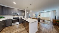 Located at 3400 E Southern Ave in Phoenix, AZ, this modern 2-bedroom, 4-bathroom residence offers a thoughtfully designed open-concept layout with contemporary finishes throughout. Wood-look flooring flows seamlessly across the entire space, lending warmth and continuity from room to room.

The kitchen is a standout feature, equipped with stainless steel appliances including a refrigerator, range, and microwave, complemented by dark espresso cabinetry, white quartz countertops, and a peninsula island with pendant lighting overhead. It opens directly into the living room, which is bright and airy, featuring a large window that invites ample natural light and a ceiling fan for comfort.

The primary bedroom is a comfortable retreat, appointed with warm neutral tones, wood-look flooring, and generous natural light. Each bedroom is paired with well-appointed bathrooms featuring dark wood vanities, white quartz countertops, and clean white tub-shower combinations. Two dedicated closets provide practical storage solutions throughout.

The overall ambiance is clean, contemporary, and cohesive, with a neutral color palette and modern fixtures that create an inviting atmosphere well-suited to everyday living in the heart of Phoenix.