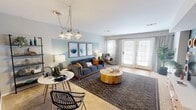 This 630 square foot, single-floor apartment in West Deptford, NJ, offers a thoughtfully designed living space. The one-bedroom layout is complemented by two bathrooms, providing convenience and privacy. The living room serves as the heart of the home, featuring a contemporary aesthetic with a gray sofa, wooden coffee table, and a striking world map wall decoration. The kitchen, while compact, is well-equipped with wooden cabinetry and white appliances. The bedroom, spanning 180 square feet, boasts a serene ambiance with a blue accent wall and modern furnishings. Throughout the apartment, a cohesive color scheme of blues, grays, and warm woods creates a harmonious atmosphere. The bathrooms are sleek and functional, with one featuring hanging plants for a touch of greenery. Large windows in the living area allow for ample natural light, enhancing the sense of space. Despite its modest size, the apartment's clever design and stylish decor make it feel both spacious and inviting.