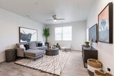 This well-appointed single-floor residence offers a contemporary open-concept design that seamlessly connects the living area, dining space, and kitchen. The living room is a bright, welcoming space featuring wood-look flooring, a ceiling fan with integrated lighting, recessed lighting, and large windows that fill the room with natural light. A private exterior door provides direct outdoor access from the living area.

The kitchen is thoughtfully designed in a galley configuration, featuring warm wood-tone cabinetry, light quartz-style countertops, stainless steel appliances including a refrigerator, range, and microwave, and a peninsula with bar seating for two. Pendant lighting above the peninsula adds an elegant accent. An adjacent walk-in pantry provides generous storage. The kitchen flows naturally into the dining area, making it ideal for entertaining.

The bedroom is a comfortable retreat with a large window allowing ample natural light, wood-look flooring, and a ceiling fan. The full bathroom is finished with matching wood-tone cabinetry, a single-sink vanity with light countertops, and a full tub-shower combination. Consistent neutral tones, clean lines, and cohesive finishes throughout the unit create a modern yet warm aesthetic.