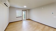 Located at 1380 Wendell Ave SE in Port Orchard, Washington, this single-level 2-bedroom, 2-bathroom residence offers a clean, modern design with functional living spaces throughout. Light-toned luxury vinyl plank flooring flows through the main living areas, complementing the bright, neutral palette of the walls and trim.

The open-concept kitchen and living area serves as the heart of the home. The kitchen features gray cabinetry, white countertops with a stainless steel sink, stainless steel appliances including a refrigerator, range, and microwave, along with ample upper and lower cabinet storage. A sliding door and adjacent window in the living area allow natural light to filter in and provide access to an outdoor balcony.

The spacious primary bedroom is carpeted and includes multiple closets for generous storage, with windows that bring in natural light. The second bedroom is similarly carpeted and features a well-sized closet with built-in shelving and hanging rods. Each bedroom is served by its own bathroom — one featuring a tub/shower combination with a vanity and mirror, and the other offering a walk-in shower stall with a matching vanity. The unit also includes a dedicated laundry area and a hallway connecting the private spaces efficiently.