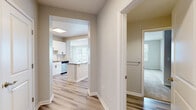 Located at 5648 Bay St in Emeryville, California, this single-story, 3-bedroom, 2-bathroom home offers a clean, modern aesthetic throughout. Light-toned luxury vinyl plank flooring flows seamlessly across the main living areas, creating a bright and cohesive feel. The open-concept kitchen is a standout feature, equipped with white shaker cabinetry with matte black hardware, a subway tile backsplash, neutral quartz-style countertops, a central island with breakfast bar, and a full suite of stainless steel appliances including a range, microwave, dishwasher, and refrigerator. The kitchen opens directly to the living area, enhancing the sense of openness and connectivity. The living room benefits from multiple windows that welcome natural light and includes track lighting overhead. The generously sized primary bedroom features large windows, hardwood-style flooring, and access to a spacious walk-in closet with wire shelving. Additional bedrooms are carpeted and include closet storage. The bathrooms are finished with light wood-style flooring, white vanities, and understated hardware. A central hallway connects all rooms efficiently, and three total closets provide ample storage throughout the home.