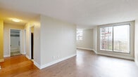 Located at 1300–1310 McWatters Road in Ottawa, Ontario, this 1-bedroom, 1-bathroom unit offers a thoughtfully designed layout across a single floor. Light-toned hardwood flooring flows throughout the main living areas and bedroom, lending warmth and continuity to the space.

The open living area is bright and airy, benefiting from large sliding windows and a balcony access point that invites natural light and outdoor views of the surrounding neighbourhood. Neutral warm-beige walls and clean white baseboards create a calm, versatile backdrop throughout.

The galley-style kitchen is efficiently organized, featuring white shaker cabinetry, dark countertops, a subway tile backsplash, and a full suite of stainless steel appliances including a refrigerator, stove, and dishwasher. Large-format tile flooring adds a polished finish to this functional space.

The generously sized primary bedroom includes a built-in double closet with white panel doors and a window for natural light. The full bathroom is finished with large-format floor tiles, white subway tile in the tub surround with a grey accent band, a white vanity with a dark countertop, and brushed nickel fixtures and grab bars.

An entry hallway connects all rooms, offering a practical transition into the unit. The textured ceilings and consistent neutral palette throughout contribute to a clean, move-in-ready aesthetic.