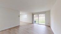 Located at 20 Deerlodge Ct in Owings Mills, MD, this well-appointed 2-bedroom, 1-bathroom residence offers a clean, modern aesthetic throughout its single floor. Light wood-style flooring runs through the main living areas, lending warmth and continuity to the open layout.

The combined kitchen and living room serves as the heart of the home. The kitchen is outfitted with crisp white shaker-style cabinetry, light countertops, a stainless steel refrigerator, gas range, and dishwasher, all illuminated by a flush ceiling light. The adjacent living area is bright and open, featuring sliding glass doors that offer direct views of a lush green yard and natural surroundings, filling the space with natural light.

Both bedrooms are carpeted for comfort and each features a built-in closet with bifold doors. The primary bedroom is generously sized and includes its own sliding glass door access to the outdoors, while the second bedroom benefits from a wide window with natural light. A connecting hallway links the bedrooms to the shared full bathroom, which is finished with classic white subway tile surrounding a tub-shower combination.

The entrance provides a welcoming transition into the home, and the overall design maintains a consistent, neutral palette throughout, creating a clean and versatile living environment.