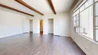 This 650 square foot apartment in Los Angeles offers a blend of classic charm and modern amenities. The living room is the focal point, featuring exposed wood beam ceilings that add character and warmth. Large windows flood the space with natural light, offering city views and creating an open, airy atmosphere. A decorative fireplace with an ornate white mantel serves as an elegant centerpiece.

The kitchen, while compact, is efficiently designed with white cabinetry, a mint green backsplash, and modern stainless steel appliances. The unique mint green sink adds a touch of retro flair. Dark wood flooring throughout provides a cohesive look and contrasts beautifully with the white walls.

Two bathrooms offer convenience, with one showcasing a striking mint green tile design that extends from floor to walls, creating a bold, vintage-inspired aesthetic. The apartment also features three closets for ample storage.

The layout is well-planned, with distinct areas for living, dining, and sleeping. The entrance leads to a hallway with built-in storage, efficiently utilizing the space. This apartment successfully combines functionality with style, making it an ideal urban dwelling in the heart of Los Angeles.