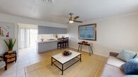 Located at 3701 E Chapman Ave in Orange, California, this two-story property offers a functional and comfortable layout designed for everyday living. The main living area is bright and welcoming, featuring light tile flooring, a ceiling fan with integrated lighting, and a large window with vertical blinds that allows ample natural light to fill the space. A framed coastal artwork and a neutral color palette lend the room a relaxed, airy ambiance.

The kitchen is thoughtfully designed with light gray lower cabinetry, white upper cabinets, and clean white countertops. It is equipped with a gas cooktop, wall oven, over-the-range microwave, and a sink with ample counter space, making it highly functional. A breakfast bar provides casual seating and connects the kitchen to the living area.

The bedrooms are carpeted for comfort and warmth, each featuring ceiling fans and windows dressed with vertical blinds that bring in natural light. The rooms offer a clean, neutral aesthetic with white walls and generous floor space.

The bathrooms include a full bath with a tub-shower combination enclosed by a sliding glass door and warm earth-tone wall tiles, as well as a half bath with granite-style countertops and tasteful wall art. The space combines practicality with understated style throughout its two floors.