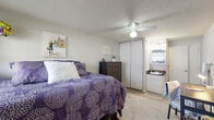 Located at 750 E 14th Ave in Eugene, Oregon, this single-floor unit offers a thoughtfully arranged and functional living space. The main bedroom serves as the heart of the unit, featuring light-toned wood-style flooring, a textured ceiling, and a ceiling fan that provides year-round comfort. A large sliding mirrored closet offers generous storage, while a window fitted with blinds allows natural light to filter into the room. The bedroom connects seamlessly to a private bathroom area, which includes a vanity with dark granite countertops, an under-mount sink, and a mirrored medicine cabinet — providing a practical and polished finish. A dedicated entry area near the front door features additional wall-mounted storage and space for a compact appliance, keeping daily essentials organized and within easy reach. The neutral color palette throughout — soft grays and whites — creates a clean, calm ambiance, while the wood-style flooring in the entry and bathroom areas adds a touch of warmth. The unit's efficient single-level layout ensures easy navigation and maximizes the use of available space, making it a practical and comfortable option in the Eugene area.