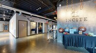 Located at 10 King Street in Troy, NY, Incite is a thoughtfully designed, single-floor commercial space that blends industrial aesthetics with modern comfort. The open floor plan is anchored by polished concrete floors and soaring exposed ceilings with visible ductwork, structural beams, and track lighting, creating a raw yet refined atmosphere throughout.

The main area is generously proportioned, accommodating multiple functional zones seamlessly. A welcoming lounge area features comfortable seating with upholstered sofas and rustic wood accents, positioned near the branded Incite signage wall. Adjacent to this is a vibrant recreation and collaboration zone with a full ping-pong table and flexible seating arrangements, all bathed in natural light from large street-facing windows that offer views of the surrounding Troy streetscape.

Tucked along one wall is a row of private office rooms, clearly labeled "The Beginning," providing enclosed spaces for focused work or meetings. The space also includes cozy booth-style seating with leather and teal upholstered banquettes set against a textured brick wall, ideal for smaller gatherings. A beverage station and display wall round out the amenities. Artwork displayed on clean white gallery walls adds a creative touch, reinforcing the space's innovative and community-driven character.