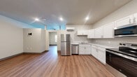 Located at 781 Fernwood Avenue in Fort Wayne, Indiana, this one-bedroom, one-bathroom unit is thoughtfully designed to maximize its compact footprint across a single floor. Wood-look flooring runs throughout the entire space, providing a warm, cohesive aesthetic.

The combined kitchen and living area forms the heart of the unit. The kitchen is well-equipped with a full suite of stainless steel appliances, including a refrigerator, electric range, over-the-range microwave, and dishwasher. White shaker-style cabinetry pairs with light countertops to create a clean, modern look. A wall-mounted mini-split system provides efficient climate control for the living area, which offers a bright and open feel with a window framing views of surrounding greenery.

The bedroom is a comfortable, well-proportioned space featuring a closet with wire shelving for organized storage. Neutral walls and consistent flooring keep the room bright and versatile.

The bathroom is notably spacious and includes both a soaking tub and a separate glass-enclosed shower stall, a vanity with cabinet storage, and a mirrored medicine cabinet. A washer is also accommodated within the bathroom, adding in-unit laundry convenience. A fire alarm system is installed throughout the unit for safety.