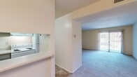 Located at 2217 Sedgwick St in Petersburg, Virginia, this one-bedroom, one-bathroom residence offers a straightforward and functional single-floor layout. The living area is carpeted and open, featuring a front entry door and a passthrough connection to the kitchen, creating a cohesive and accessible flow between spaces. A large sliding glass door brings in generous natural light and provides an outdoor view, enhancing the sense of openness in the living area. The kitchen is efficiently arranged with gray cabinetry, a white electric coil range, a refrigerator, a dishwasher, and light stone-patterned tile flooring. A built-in countertop pass-through connects the kitchen to the main living space, adding a practical and social element to the layout. The bedroom is a comfortable size, featuring plush carpet, a wide louvered double closet for ample storage, and a window that fills the room with natural light. The bathroom includes a full tub-shower combination with built-in corner shelving and clean white surrounds. A hallway connects the main rooms, maintaining a logical and private separation between living and sleeping areas. Throughout the unit, neutral tones and light-colored walls create a clean, move-in-ready atmosphere.