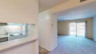 Located at 2217 Sedgwick St in Petersburg, Virginia, this one-bedroom, one-bathroom residence offers a straightforward and functional single-floor layout. The living area is carpeted and open, featuring a front entry door and a passthrough connection to the kitchen, creating a cohesive and accessible flow between spaces. A large sliding glass door brings in generous natural light and provides an outdoor view, enhancing the sense of openness in the living area. The kitchen is efficiently arranged with gray cabinetry, a white electric coil range, a refrigerator, a dishwasher, and light stone-patterned tile flooring. A built-in countertop pass-through connects the kitchen to the main living space, adding a practical and social element to the layout. The bedroom is a comfortable size, featuring plush carpet, a wide louvered double closet for ample storage, and a window that fills the room with natural light. The bathroom includes a full tub-shower combination with built-in corner shelving and clean white surrounds. A hallway connects the main rooms, maintaining a logical and private separation between living and sleeping areas. Throughout the unit, neutral tones and light-colored walls create a clean, move-in-ready atmosphere.