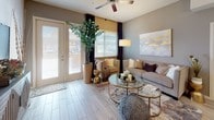 This single-story residence offers a thoughtfully designed open-concept layout that connects the kitchen, dining, and living areas into a cohesive and functional living environment. The kitchen is a standout feature, equipped with an extensive array of white shaker cabinetry, granite countertops, and a full suite of stainless steel appliances including a side-by-side refrigerator, range, over-the-range microwave, and dishwasher. Light wood-look flooring flows throughout the home, adding warmth and visual continuity across each room.

The dining area benefits from natural light and is anchored by an elegant chandelier, creating an inviting atmosphere for gathering. The living room features a ceiling fan, large windows with privacy blinds, and French doors that open to an outdoor space, filling the room with natural light.

The primary bedroom is a serene retreat with direct outdoor access via French doors, a ceiling fan, and a walk-in closet. Its en-suite bathroom includes granite countertops, white cabinetry, and wood-look tile flooring. Additional bedrooms offer closet storage and ample natural light. A secondary bathroom mirrors the same refined finishes found throughout the home, maintaining a consistent and polished aesthetic.