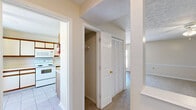 Located at 46 Hampton Cir in Warner Robins, Georgia, this two-story home offers a practical and well-organized layout split evenly between its two floors. The main level houses the kitchen, living room, hallways, and closet storage, while the upper level is dedicated to the bedrooms and additional bathrooms.

The kitchen features tile flooring, cream-toned cabinetry with wood accents, a full suite of white appliances including an electric range, microwave, and refrigerator, and a double sink with ample counter space. It opens toward the living area, which transitions to wood-look flooring and is brightened by a door with exterior access and natural light.

The upper floor contains both bedrooms, each finished with neutral carpet, ceiling fans with light fixtures, and textured ceilings. The spacious primary bedroom includes a closet and connects to a well-appointed bathroom featuring a vanity with a large mirror, wood-toned cabinetry, hardwood flooring, and a tub-shower combination. The second bedroom also features carpet and a window with an exterior view. Throughout the home, louvered closet doors, wainscoting-style wall trim, and a consistent neutral color palette contribute to a cohesive, understated aesthetic.