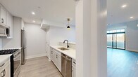 Located at 282 South Ave in Fanwood, NJ, this thoughtfully designed two-story residence offers 2 bedrooms, 3 bathrooms, a loft, and a private balcony across two well-proportioned floors. The main level sets a welcoming tone with an open-concept kitchen and living area anchored by a beadboard island, light cabinetry, subway tile backsplash, stainless steel appliances, and elegant black-and-gold pendant lighting. Light hardwood-style flooring flows throughout, complementing the crisp white walls and clean modern aesthetic. A dedicated mudroom entry features built-in beadboard paneling, gold coat hooks, an upper shelf, and a bench — a practical and charming transition space. The upper level hosts the generously sized primary bedroom, which opens directly onto the private balcony through floor-to-ceiling sliding glass doors topped with transom windows, flooding the space with natural light and outdoor views. A second bedroom features vaulted ceilings with exposed angles and a ceiling fan, adding architectural character. The loft level offers built-in shelving and an open railing staircase. Three bathrooms are finished with large-format tile, backlit mirrors, and refined vanities. Abundant closet storage, a pantry, and a utility room round out this well-appointed home.
