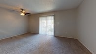Located at 240 Burt St in Santa Rosa, California, this single-story unit offers a practical and well-organized layout across several distinct living areas. The main living room is generously proportioned, featuring neutral-toned carpet, a textured ceiling, a ceiling fan with light fixture, and a sliding glass door framed by vertical blinds that allows natural light to fill the space and provides access to an outdoor area.

The kitchen is designed with an open-concept pass-through configuration, featuring warm wood cabinetry, granite-style countertops, and stainless steel appliances including a refrigerator. The raised breakfast bar separates the kitchen from the adjacent dining or living area, creating a connected yet defined space.

The bedrooms are carpeted and feature neutral walls with ample natural light. One bedroom includes a sliding mirrored closet with built-in shelving and hanging rods for organized storage, while another offers en-suite access to a full bathroom. A second bedroom is bright and open with good proportions.

Both bathrooms are similarly appointed, each featuring a granite-top vanity with wood cabinetry, a large mirror, a tub-shower combination, and wood-style vinyl flooring, lending a cohesive and clean aesthetic throughout. The overall ambiance of the unit is calm, neutral, and move-in ready.