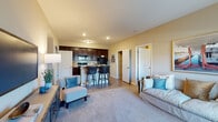 Located at 6262 Skye Isle Blvd. in Columbus, Ohio, this single-floor residence offers a thoughtfully designed layout that balances comfort and functionality. The open-concept living area features plush carpeting, warm neutral walls, and seamless flow into the kitchen, creating an inviting and connected space. The kitchen is a standout feature, showcasing rich dark-wood cabinetry extending to the ceiling, light granite countertops, wood-look flooring, and a full suite of black appliances including a refrigerator, range, and microwave. A peninsula with bar seating adds both workspace and casual dining. The primary bedroom is generously proportioned with vaulted ceilings, natural light from a large window, and soft carpeting. A second bedroom also benefits from natural light and comfortable carpeting. Both bathrooms are finished with large-format stone-look tile flooring, dark espresso vanity cabinetry, granite countertops, and well-lit mirrors. The primary bath includes a tub/shower combination, while the secondary bath features a refined single-vanity setup. Throughout the residence, a cohesive warm color palette, recessed lighting, and clean architectural lines contribute to a calm, modern ambiance well-suited for everyday living.