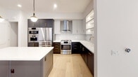 Located in the heart of Los Angeles, this single-story residence at 1333 S Orange Grove Ave offers a thoughtfully designed modern interior with high-quality finishes throughout. Wide-plank light oak hardwood flooring flows seamlessly across the living areas and bedrooms, creating a warm and cohesive aesthetic complemented by crisp white walls and recessed lighting.

The chef's kitchen is a standout feature, boasting two-tone cabinetry in charcoal and light gray with brass hardware, sleek white quartz countertops, a subway tile backsplash, and a full suite of stainless steel Bosch appliances including a French door refrigerator, wall oven, built-in microwave, and gas range with a stainless steel hood. A walk-in pantry with open wood shelving provides generous storage. Globe pendant lighting adds a refined touch.

The bedrooms are bright and airy, each featuring black-framed windows that frame views of the surrounding neighborhood and allow abundant natural light. Closets with open shelving systems offer practical organization.

The bathrooms are finished to a spa-like standard, featuring floating wood vanities with white quartz countertops, backlit mirrors, matte black fixtures, large-format tile flooring, and a glass-enclosed walk-in shower with floor-to-ceiling tile. The living area is expansive and open, with French doors leading to an outdoor space, completing this refined Los Angeles residence.