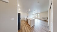 Located at 1779 Village Ln SE in Port Orchard, WA, this single-floor residence offers three bedrooms and three bathrooms with a clean, modern aesthetic throughout. The open-concept kitchen and living area serves as the heart of the home, featuring a large quartz-topped island with an undermount sink and matte black faucet, white shaker cabinetry with black hardware, quartz countertops, and stainless steel appliances including a refrigerator, range, and microwave. Wood-look luxury vinyl plank flooring runs consistently throughout the entire space, lending warmth and cohesion to every room. The living area is bright and airy, with large windows that bring in natural light and offer views of the surrounding neighborhood. The primary bedroom provides a comfortable retreat with a double-door closet and direct access to its own bathroom. The additional bedrooms each include closet storage and share access to well-appointed bathrooms. Each bathroom is finished with white shaker vanities, quartz countertops, matte black fixtures, and large mirrors. One bathroom features a full soaking tub with shower, while another offers a streamlined shower and vanity setup. The overall design is characterized by neutral tones, consistent modern hardware, and a bright, move-in-ready condition throughout.