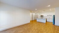 Located at 2110 E Southport Rd in Southport, Indiana, this well-appointed 2-bedroom, 2-bathroom single-floor residence offers a thoughtfully designed open-concept layout. The combined kitchen and living area serves as the heart of the home, highlighted by crisp white shaker cabinetry, a subway tile backsplash, a large center island with a quartz countertop, and pendant lighting overhead. Stainless steel appliances — including a gas range, microwave, and refrigerator — complete the kitchen. Warm wood-style flooring flows seamlessly throughout the entire unit, complementing the clean white walls and recessed lighting that keep the space bright and inviting. The spacious primary bedroom features a ceiling fan and natural light from a large window, while the second bedroom offers its own closet and comfortable proportions. Both bathrooms echo the home's modern aesthetic with white vanity cabinetry and wood-style flooring. Three closets provide generous storage, and a dedicated laundry area adds everyday convenience. A utility room houses the water heater and HVAC system. The overall design is clean, contemporary, and move-in ready.