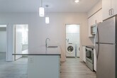 Located at 772 Paisley Rd in Guelph, Ontario, this well-designed 2-bedroom, 2-bathroom unit offers a thoughtful layout across a single floor. The open-concept living, dining, and kitchen area forms the heart of the unit, finished with light grey wood-look flooring that runs throughout. The kitchen is a standout feature, equipped with stainless steel appliances including a refrigerator, stove, and built-in microwave, complemented by crisp white cabinetry, a grey quartz-style countertop, and a peninsula with an integrated sink — illuminated by stylish pendant lights overhead. The spacious living and dining area is bathed in natural light from large windows with outdoor views. The primary bedroom is a comfortable, well-sized room with its own window, while the second bedroom offers a clean, neutral space with natural light. The two bathrooms are finished in a consistent, modern style — one featuring a glass-enclosed stand-up shower with a sleek vanity, and the other a full soaker tub. A dedicated in-suite laundry room houses a full-sized Whirlpool washer and dryer with overhead shelving. The unit also includes a private balcony and a closet for additional storage.