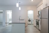 Located at 772 Paisley Rd in Guelph, Ontario, this well-designed 2-bedroom, 2-bathroom unit offers a thoughtful layout across a single floor. The open-concept living, dining, and kitchen area forms the heart of the unit, finished with light grey wood-look flooring that runs throughout. The kitchen is a standout feature, equipped with stainless steel appliances including a refrigerator, stove, and built-in microwave, complemented by crisp white cabinetry, a grey quartz-style countertop, and a peninsula with an integrated sink — illuminated by stylish pendant lights overhead. The spacious living and dining area is bathed in natural light from large windows with outdoor views. The primary bedroom is a comfortable, well-sized room with its own window, while the second bedroom offers a clean, neutral space with natural light. The two bathrooms are finished in a consistent, modern style — one featuring a glass-enclosed stand-up shower with a sleek vanity, and the other a full soaker tub. A dedicated in-suite laundry room houses a full-sized Whirlpool washer and dryer with overhead shelving. The unit also includes a private balcony and a closet for additional storage.
