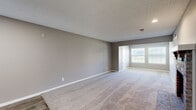 This single-floor residence offers a functional and comfortable layout across two bedrooms and two full bathrooms. The open-concept living, dining, and kitchen area serves as the heart of the home, highlighted by a classic brick fireplace with a white mantel and a pass-through window connecting to the kitchen. The living space transitions seamlessly between plush carpet and wood-look hard flooring, and a front-facing window fills the area with natural light.

The spacious primary bedroom features carpet flooring, a ceiling fan with light fixture, a generous walk-in closet with built-in shelving, and a window with blinds. The second bedroom is similarly appointed with carpet flooring, a ceiling fan, and its own closet, with convenient access to the adjacent full bathroom. Both bathrooms include tiled tub-and-shower combinations with chrome fixtures — one with wood-look flooring for added warmth.

Throughout the residence, neutral gray walls, textured ceilings, and white trim create a clean, cohesive aesthetic. Four closets provide exceptional storage capacity. A dedicated laundry area adds everyday convenience. The overall ambiance is practical and move-in ready, offering a comfortable living environment with consistent finishes throughout.