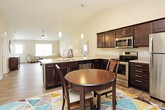 This single-story residence offers a thoughtfully designed layout that balances comfort and functionality throughout its living spaces. The open-concept kitchen serves as a focal point, featuring rich dark-espresso cabinetry, granite-look countertops, a double-basin sink, and a full suite of stainless steel appliances including a range, over-the-range microwave, and refrigerator. Vaulted ceilings above the kitchen and adjoining dining area enhance the sense of openness, while wood-look flooring ties the space together seamlessly.

The living room continues the wood-look flooring and is brightened by natural light from a large window fitted with blinds. A ceiling fan overhead provides efficient air circulation. The neutral wall tones throughout create a calm, cohesive aesthetic.

The bedrooms are finished with plush carpet and ceiling fans, each offering a comfortable and quiet retreat. Natural light filters in through windows with blinds. The primary bedroom connects directly to a private bathroom, which includes a walk-in closet with wire shelving, a tub/shower combination, a dark-cabinetry vanity with granite-look countertops, and wood-look flooring. An additional bathroom mirrors this finish quality, maintaining a consistent and polished look throughout the home.