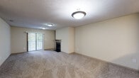 Located at 2419 Old Thompson Bridge Rd in Gainesville, GA, this single-floor unit offers a practical and comfortable layout designed for everyday living. An entry hallway with wood-look flooring leads into the main living areas, providing a clear transition between spaces. The spacious living room is carpeted and centers around a tiled fireplace, adding warmth and character to the room. A sliding glass door floods the space with natural light and offers views to the outdoors. The living room opens directly to the kitchen via a pass-through counter, creating an open and connected feel. The galley-style kitchen is well-appointed with light wood cabinetry, dark granite-style countertops, a double basin sink, and a full suite of stainless steel appliances including a refrigerator, range, and microwave. The unit includes multiple carpeted bedrooms, each featuring neutral walls and textured ceilings. One bedroom includes a closet with built-in wire shelving and a dedicated walk-in closet, offering generous storage. The bathroom is finished with a wide vanity featuring dark countertops, a large mirror, and a shower-tub combination. Wood-look flooring extends through the entry and wet areas, complementing the neutral, move-in-ready aesthetic throughout.