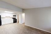 Located at 3237 Yanceyville St in Greensboro, NC, this one-bedroom, one-bathroom unit offers a practical and well-organized single-floor layout. Wood-look flooring runs consistently throughout the space, lending a cohesive, clean aesthetic to every room.

The open-plan kitchen and living area serves as the heart of the unit. The kitchen is outfitted with white shaker-style cabinetry reaching toward the ceiling, light granite-patterned countertops, a stainless steel sink, and black appliances including a refrigerator, electric range, and range hood. A skylight overhead fills the kitchen with natural light, creating a bright and functional cooking environment. The living area flows directly from the kitchen, offering an open and versatile space with neutral gray walls and a large window that allows additional natural light.

The bedroom is a comfortable, well-proportioned room featuring crown molding, a textured ceiling, a window with exterior views, and direct access to the hallway. Three closets throughout the unit provide generous storage capacity. The full bathroom includes a tub/shower combo and toilet, finished with the same wood-look flooring. A dedicated utility room and hallway complete the layout, contributing to the unit's efficient and functional design.