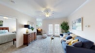 Located at 2118 Silvercrest Drive in Myrtle Beach, SC, this single-floor, 2-bedroom, 2-bathroom residence offers a thoughtfully organized layout across a comfortable footprint. The living room serves as the heart of the home, featuring plush carpeting, crown molding, a ceiling fan, and bright French doors that invite natural light and outdoor views. An octagonal accent window adds architectural character to the space. The adjacent dining room is distinguished by elegant wainscoting, crown molding, and a classic wrought-iron chandelier, creating an inviting setting for meals. The galley-style kitchen is efficiently designed with ample light wood cabinetry, generous counter space, tile flooring, and a full suite of white appliances, with direct access to a dedicated utility room. The primary bedroom is a serene retreat with carpet flooring, crown molding, a ceiling fan, and a large window overlooking greenery. It includes a walk-in closet and an en-suite bathroom featuring a dual-sink vanity with warm wood cabinetry and a large mirror. The second bathroom offers a tub-shower combination with tile flooring. A hallway and additional closet provide practical storage throughout this well-designed Myrtle Beach home.