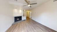 Located in Millcreek, Utah, this one-bedroom, two-bathroom residence offers a practical and comfortable single-floor layout. The open living room is a welcoming focal point, featuring a wood-burning fireplace with a tiled surround, wood-look flooring, a ceiling fan, and a sliding glass door that fills the space with natural light and provides outdoor access. A second living area or bonus room also features a ceiling fan and a window, adding flexibility to the floor plan. The galley-style kitchen is efficiently designed with white cabinetry, track lighting, a stainless steel sink, and appliances, seamlessly connecting to the main living areas. The generously sized bedroom is carpeted for warmth and comfort, and includes a dedicated walk-in closet with built-in shelving. Both bathrooms are well-appointed — one features a wide vanity with white cabinetry, a white quartz countertop, an undermount sink, and a large mirror, while the other includes a full soaking tub and shower combination with clean grey subway tile surround and chrome fixtures. Throughout the home, crisp white walls and light-toned finishes create a bright and cohesive ambiance.