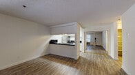 Located at 16183 Ashland Ave in San Lorenzo, California, this single-story unit offers a practical and functional layout with a clear separation between living, sleeping, and kitchen areas. The main living space features wood-style laminate flooring and is bathed in natural light through large windows fitted with vertical blinds. A wall-mounted air conditioning unit provides climate control, and a textured ceiling runs throughout the common areas.

The galley-style kitchen is well-appointed, featuring white cabinetry extending to the ceiling, dark granite-style countertops, and stainless steel appliances including a refrigerator, dishwasher, and range. An overhead pass-through window connects the kitchen to the living area, enhancing the sense of openness. Tile-style flooring and recessed lighting complete the kitchen's clean, efficient design.

The bedroom is carpeted and offers a closet with mirrored sliding doors, allowing natural light to reflect throughout the room. A window provides outdoor views and additional light. The full bathroom includes a tub-shower combination with white tile surround, a vanity with dark countertops, wood-style flooring, and chrome fixtures, presenting a clean and functional finish throughout.
