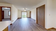 Located at 938 4th St in Fond du Lac, Wisconsin, this single-floor, 2-bedroom, 2-bathroom home offers a practical and comfortable layout. The kitchen is well-appointed with ample cream and wood-toned cabinetry, a double-basin sink, white appliances including a dishwasher, range, and refrigerator, and a peninsula that opens to the adjacent dining area. A chandelier accent light adds a touch of warmth to the dining space. The living area features durable wood-look flooring, a ceiling fan, and a sliding glass door that invites natural light and provides direct outdoor access. Both bedrooms are carpeted and finished with warm wood trim throughout. The generously sized primary bedroom includes a walk-in closet outfitted with wire shelving and hanging rods on wood-look flooring, offering excellent storage capacity. The two bathrooms each include a tub-shower combination and wood-look flooring; one features a skylight and a vanity with a stone-look countertop. Throughout the home, consistent wood-trimmed doors, neutral wall tones, and textured ceilings create a cohesive and functional living environment.
