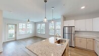 Located at 2410 Smith Gln Rd in Charlotte, NC, this well-designed one-bedroom, one-bathroom residence offers a thoughtfully organized single-floor layout. Wood-look flooring flows consistently throughout the space, lending warmth and visual continuity from room to room.

The open-concept kitchen and living area serves as the heart of the home. The kitchen is outfitted with white shaker-style cabinetry, granite countertops, a herringbone-patterned tile backsplash, stainless steel appliances, and a central island with a built-in sink and pendant lighting overhead — a functional and attractive setup for cooking and entertaining.

The living area is bright and welcoming, benefiting from multiple windows dressed with blinds that invite generous natural light. A ceiling fan provides added comfort, and the open sightlines create a sense of spaciousness.

The bedroom is comfortably sized, featuring its own ceiling fan, natural light from dual windows, and direct access to a dedicated closet — providing practical storage in a clean, understated space.

The bathroom is finished with a clean, neutral palette, featuring a full tub-shower combination with built-in shelving and chrome fixtures, complemented by wood-look flooring that ties back to the rest of the unit.

A connecting hallway links the main living spaces efficiently, completing this cohesive and move-in-ready residence.