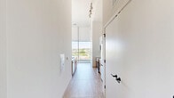 Located in the heart of downtown Wilmington at 517 N Shipley St, this thoughtfully designed one-bedroom, one-bathroom residence offers a contemporary living experience defined by clean lines, high ceilings, and abundant natural light. Light-toned hardwood flooring flows throughout the main living areas, complementing the crisp white walls and creating a bright, airy ambiance.

The galley-style kitchen is well-appointed with stainless steel appliances — including a refrigerator, electric range, and over-the-range microwave — paired with warm wood cabinetry, white quartz countertops, and a stainless undermount sink with a matte black faucet. Floor-to-ceiling windows in the kitchen frame sweeping views of the Wilmington skyline.

The spacious primary bedroom features soaring ceilings, a wall-mounted split HVAC unit, and dramatic floor-to-ceiling windows that deliver expansive elevated views of the surrounding cityscape. A dedicated closet provides practical storage off the bedroom.

The bathroom is finished in a modern style with a wood-toned vanity, white countertop, a large framed mirror, and matte black hardware and fixtures throughout.

Throughout the unit, the generous ceiling height enhances the sense of openness, while large-format windows ensure natural light reaches every corner. This residence offers a refined urban living experience in one of Wilmington's most accessible downtown locations.