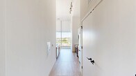 Located in the heart of downtown Wilmington at 517 N Shipley St, this thoughtfully designed one-bedroom, one-bathroom residence offers a contemporary living experience defined by clean lines, high ceilings, and abundant natural light. Light-toned hardwood flooring flows throughout the main living areas, complementing the crisp white walls and creating a bright, airy ambiance.

The galley-style kitchen is well-appointed with stainless steel appliances — including a refrigerator, electric range, and over-the-range microwave — paired with warm wood cabinetry, white quartz countertops, and a stainless undermount sink with a matte black faucet. Floor-to-ceiling windows in the kitchen frame sweeping views of the Wilmington skyline.

The spacious primary bedroom features soaring ceilings, a wall-mounted split HVAC unit, and dramatic floor-to-ceiling windows that deliver expansive elevated views of the surrounding cityscape. A dedicated closet provides practical storage off the bedroom.

The bathroom is finished in a modern style with a wood-toned vanity, white countertop, a large framed mirror, and matte black hardware and fixtures throughout.

Throughout the unit, the generous ceiling height enhances the sense of openness, while large-format windows ensure natural light reaches every corner. This residence offers a refined urban living experience in one of Wilmington's most accessible downtown locations.