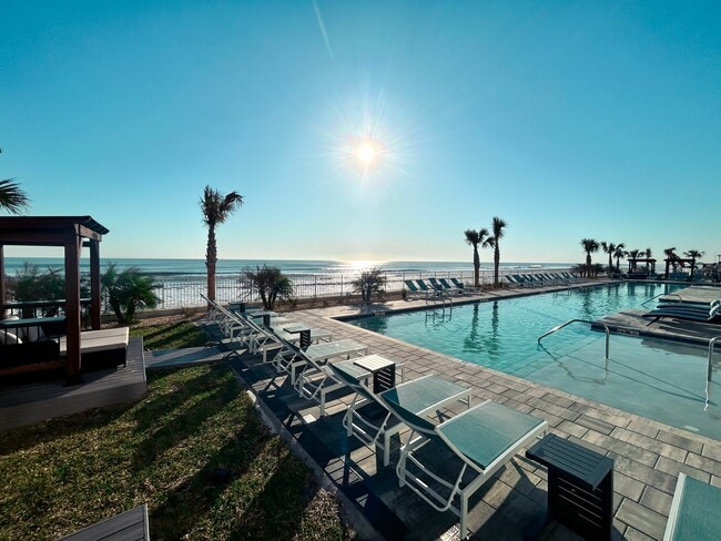 Bask in the sun by the poolside and soak up the perfect day of leisure. - Triton Cay - Daytona Apartments