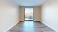 Located at 538 Bond Ave NW in Grand Rapids, Michigan, this two-bedroom, two-bathroom unit offers a well-designed single-floor layout with a clean, contemporary aesthetic throughout. The open-concept living, dining, and kitchen area serves as the heart of the home, featuring warm hardwood-style flooring, neutral wall tones, and a sliding glass door that opens onto a private balcony with outdoor views. The kitchen is equipped with stainless steel appliances, gray shaker-style cabinetry, dark granite countertops, a peninsula with an undermount sink, and track lighting overhead — ideal for both cooking and entertaining. The spacious primary bedroom offers generous square footage, light wood flooring, and direct access to a well-appointed en-suite bathroom featuring granite counters, gray cabinetry, warm tile flooring, and a tub-shower combination with full tile surround. The second bedroom is bright and comfortably sized with light flooring and natural light from a nearby window. The second bathroom mirrors the refined finishes of the first, with a granite-topped vanity and tile flooring. Three closets provide ample storage, and a dedicated laundry area adds everyday convenience. The overall ambiance is modern, clean, and move-in ready.