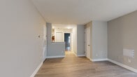 Located at 415 W 10th Street in Charlotte, NC, this single-floor residence offers a clean, updated interior with a cohesive neutral palette and wood-style flooring throughout. The open living area is bright and welcoming, highlighted by a distinctive angled bay window arrangement that invites natural light and provides street-facing views. A front entry door with a secure lock opens directly into this comfortable living space.

The kitchen is thoughtfully outfitted with crisp white cabinetry, granite countertops, a stainless steel sink, a built-in dishwasher, and a full-size stainless steel refrigerator. A peninsula counter provides additional prep space and casual seating potential, seamlessly connecting the kitchen to the main living area.

The bedroom features durable wood-style flooring, a window overlooking a fenced outdoor area, and ample closet storage with built-in shelving and hanging rods accessible via bifold doors. A secondary door provides convenient access to the exterior. The bathroom is neatly appointed with a vanity, framed mirror, and tile-style flooring. Additional utility provisions, including laundry hookups, are also present. The overall design is practical and move-in ready, situated in close proximity to Uptown Charlotte's amenities.