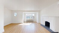Located at 1214 Avenue Rd, Unit 3 in Toronto's sought-after Avenue Road corridor, this well-appointed 2-bedroom, 1-bathroom unit offers a thoughtfully designed single-floor layout. The expansive living area is divided into two connected zones by a striking arched doorway, lending an elegant architectural character to the space. Light hardwood flooring flows throughout, complementing the crisp white walls and recessed lighting. A classic white fireplace with a decorative mantel serves as a focal point, while a ductless mini-split unit and traditional cast-iron radiators provide climate control year-round. Large windows allow abundant natural light to fill the space. The modern kitchen features white shaker-style lower cabinets, light wood upper cabinetry, white quartz countertops, a black hardware accents, a double undermount sink, and stainless steel appliances. The bathroom is finished with a wood-toned vanity, dark countertop, arched mirror, and tiled flooring. Both bedrooms are bright and comfortable, each with radiator heating and hardwood floors. A dedicated laundry room with washer and dryer adds everyday convenience. A covered private balcony with wood detailing and neighbourhood views completes this well-rounded unit.