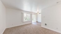 This single-floor, 3-bedroom, 1-bathroom home offers a clean and functional layout with a bright, welcoming atmosphere throughout. The living area is a standout space, featuring plush wall-to-wall carpeting, crisp white walls, and a ceiling fan overhead. Large windows flood the room with natural light, while a sliding glass door provides direct outdoor access and views of surrounding greenery, creating a seamless indoor-outdoor connection. A wall-mounted heating unit ensures year-round comfort.

Each of the three bedrooms continues the carpeted flooring and neutral white palette. The primary bedroom is a comfortable, well-proportioned retreat, while the secondary bedrooms benefit from natural light provided by windows overlooking lush trees. Several bedrooms include built-in closets with sliding doors, shelving, and hanging rods for practical storage. Wall-mounted heating units are present in multiple rooms.

The bathroom is tastefully finished with wood-look flooring, a white vanity with a quartz-style countertop, a black-framed mirror, and a full tub-and-shower combination accented with warm beige tile surround and chrome fixtures.

A connecting hallway ties the rooms together, completing a cohesive, efficiently designed home that balances simplicity with functional comfort throughout.