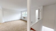 Located at 4 Brookside Drive East in Harriman, NY, this two-bedroom, two-bathroom home offers a clean, functional layout designed for comfortable everyday living. The bright living room features neutral carpet flooring, a wall-mounted air conditioning unit, and wide windows that invite natural light and views of the surrounding greenery. Adjacent to the living area, the dining room provides a seamless flow for entertaining. The kitchen is well-appointed with white shaker-style cabinetry, light wood laminate flooring, ample counter space, and stainless steel appliances including a range and refrigerator. A hallway connects the main living areas to the two carpeted bedrooms, each warmed by baseboard heating and featuring windows overlooking the outdoors. The generously sized primary bedroom includes two closets and direct access to a full bathroom. A second full bathroom, finished with classic white tile flooring, a vanity with mirror cabinet, and a tub-shower combination, serves the remainder of the home. Five closets throughout provide excellent storage. The home's crisp white walls and consistent finishes create a clean, move-in-ready atmosphere throughout.