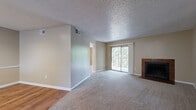 Located at 11800 Pleasant Ridge Rd in Little Rock, Arkansas, this single-floor, one-bedroom, one-bathroom residence offers a practical and comfortable layout. The living room is a generous, carpet-floored space highlighted by a tile-surround wood-burning fireplace, a textured ceiling, and sliding glass doors that open to a private balcony, allowing natural light and outdoor views to fill the room. Transitioning from the living area, the kitchen features warm oak cabinetry, light countertops, hardwood flooring, and black appliances including a range, over-the-range microwave, and refrigerator. A breakfast bar peninsula provides a convenient separation between the kitchen and the adjacent dining area. The spacious primary bedroom is finished with plush carpeting, a ceiling fan with light fixture, mirrored sliding closet doors, and a window that brings in natural light. The full bathroom includes a tub-shower combination with tile surround, hardwood flooring, and a vanity with storage. Neutral warm-toned walls throughout create a cohesive and inviting ambiance across all rooms.