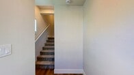This contemporary townhouse in Portland, Oregon, offers a well-designed living space across two floors. The 850 square foot interior is thoughtfully divided, with 430 sq ft on the ground floor and 420 sq ft upstairs. The home features two bedrooms, including a spacious 130 sq ft primary bedroom, and two full bathrooms.

The interior showcases a blend of materials, with sleek hardwood flooring in the main living areas and plush carpeting in the bedrooms. Large windows throughout flood the space with natural light and offer views of the surrounding neighborhood. The open-concept kitchen and living area on the main floor creates a sense of spaciousness, featuring modern white cabinetry, stainless steel appliances, and a neutral subway tile backsplash.

Both bathrooms are outfitted with contemporary fixtures, including a glass-enclosed shower in one and a tub-shower combination in the other. The home's neutral color palette and clean lines contribute to its modern aesthetic, while built-in closets in the bedrooms provide ample storage. Two staircases connect the floors, enhancing the home's flow and functionality. This townhouse presents an ideal blend of style and practicality in an urban setting.