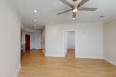 Located at 4650 Washington Ave in New Orleans, LA, this well-designed one-bedroom, one-bathroom unit offers a thoughtful layout across a single floor. Light wood-look tile flooring flows continuously throughout the space, lending a cohesive and modern aesthetic.

The open-concept living, dining, and kitchen area forms the heart of the unit. The galley-style kitchen is outfitted with flat-front, light wood cabinetry extending to the ceiling for ample storage, stainless steel appliances including a refrigerator, electric range, microwave, and dishwasher, and a double-basin sink set into clean white countertops. Recessed lighting and a ceiling fan keep the living area bright and comfortable.

The bedroom is a well-proportioned retreat featuring a ceiling fan, crown molding, and a window with exterior views that brings in natural light. A dedicated closet provides practical storage.

The bathroom is finished with a floating wood-tone vanity topped with a backlit mirror, a walk-in glass-enclosed shower accented with striking blue decorative tile, and wood-look tile flooring that ties in with the rest of the unit.

Additional conveniences include an in-unit laundry area, recessed lighting throughout, and a visible electrical panel. The overall design is clean, contemporary, and move-in ready.