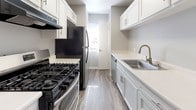 Located at 220 Burt St in Santa Rosa, California, this single-floor residence offers a thoughtfully laid-out living space with a clean, modern aesthetic throughout. The galley-style kitchen is a standout feature, showcasing white shaker cabinetry, light quartz countertops, wood-look flooring, and a full suite of black stainless steel appliances including a gas range, refrigerator, and dishwasher, complemented by a brushed gold faucet at the stainless steel sink. The living area is finished with plush carpet, neutral gray walls, and a ceiling fan with light fixture, creating a comfortable and versatile space. A dedicated closet with built-in shelving provides convenient storage off the main living area. The bedroom features carpet flooring, a mirrored sliding-door closet, a wall-mounted mini-split HVAC unit, and a window that brings in natural light and outdoor views. The bathroom is clean and functional, appointed with wood-look tile flooring, a white vanity, and a tub-shower combination with brushed nickel fixtures. A stacked in-unit washer and dryer adds everyday convenience. Neutral tones and textured ceilings are consistent throughout, giving the home a cohesive and move-in-ready feel.