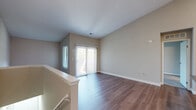 Located in Sterling Heights, Michigan, this single-floor, 2-bedroom, 2-bathroom residence offers a well-organized layout designed for comfortable everyday living. The open-concept living room features warm hardwood-style flooring, vaulted ceilings, neutral-toned walls, and a sliding glass door flanked by vertical blinds that floods the space with natural light and provides direct access to a private patio. The kitchen is equipped with crisp white shaker-style cabinetry, gray quartz-style countertops, stainless steel appliances including a refrigerator, range, and microwave, and a classic subway tile backsplash. A kitchen island adds additional counter space and storage. An adjacent laundry area with cabinetry provides convenient in-unit utility. Both bedrooms feature plush carpeting, neutral walls, and windows with blinds that allow natural light. The primary bedroom offers a generous footprint with ample closet space. The two bathrooms are finished with large-format gray tile; one includes a soaking tub with tiled surround, while the other features a walk-in shower. Three closets throughout the unit ensure practical storage. The overall aesthetic is clean, modern, and cohesive.