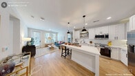 Located at 101 Southcenter Ct in Morrisville, NC, this single-floor, 2-bedroom, 2-bathroom residence offers a thoughtfully designed layout with modern finishes and a bright, welcoming ambiance. The open-concept kitchen and living area serves as the heart of the home, where crisp white shaker cabinetry, stainless steel appliances, a subway tile backsplash, and a large central island with seating create an efficient and stylish culinary space. Pendant lighting and recessed fixtures illuminate the area, while light wood-style flooring flows seamlessly throughout. The adjacent living room benefits from large windows that invite generous natural light and provide outdoor views, enhancing the sense of openness. A connecting hallway leads to both bedrooms, each offering a comfortable and private retreat with well-proportioned layouts. The primary bedroom is a spacious sanctuary, while the second bedroom offers equal charm. Both closets feature built-in shelving and hanging rods for practical storage. The two bathrooms are clean and functional, with one featuring a tiled tub-shower combination. Neutral wall tones and consistent flooring tie the entire residence together, creating a cohesive and modern living environment.